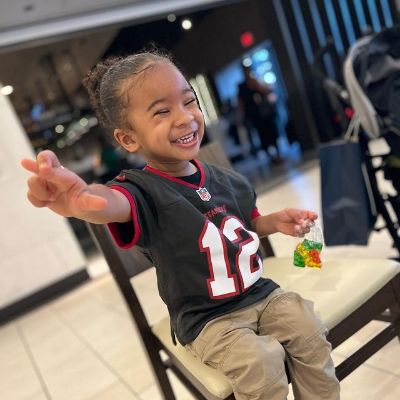 He is smiling as he crosses his fingers.